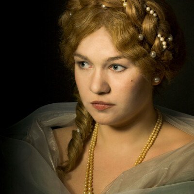 "Transport yourself to the Romantic Era with Lisa V., elegantly adorned in a chignon hairstyle and period attire. 💖 Photographer, makeup artist, and hairstylist: Anett Alexandra Bulano. #RomanticEra #VictorianFashion" "Portrait of Lisa V. in Romantic Era attire, featuring a chignon hairstyle with a central braid adorned with pearls. Styled and photographed by Anett Alexandra Bulano."